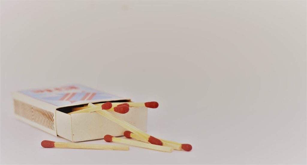 red-and-brown-safety-match-with-box-961061 A close-up of an open matchbox with scattered matches on a white surface. Ideal for safety themes.